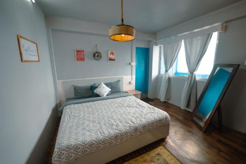 a bedroom with a bed and a large window at Monratino The snow roost- 10 mins walking distance from mall road- Attached balcony with Kanchenjunga Mountain View-Kitchen available in Darjeeling