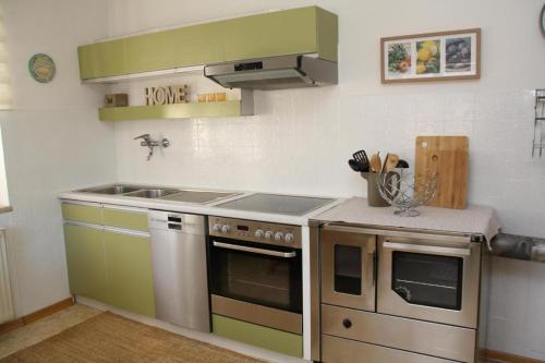 a kitchen with a stove and a sink at Haus Sonnental, Velden am Wörthersee in Fahrendorf