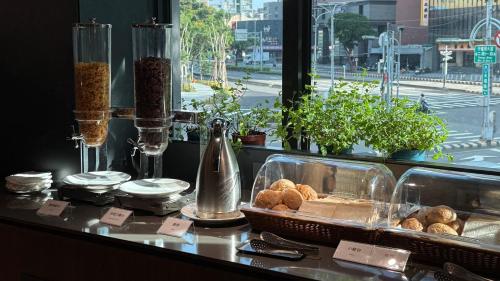 a table with a basket of pastries and a window at Talmud Hotel Classic Taiwan Boulevard in Taichung