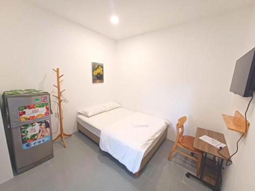 a bedroom with a bed and a small refrigerator at Yen Minh Resthouse in Ho Chi Minh City