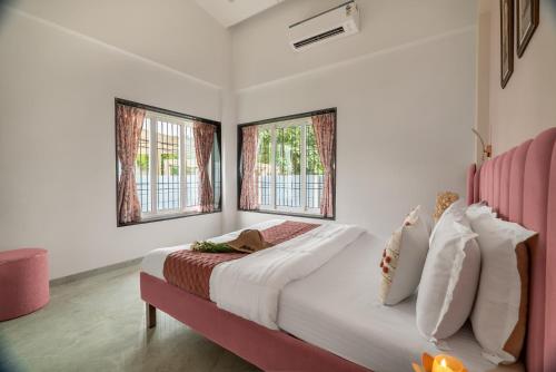 a bedroom with a large bed and two windows at Villa Azure Bliss by Riviera Hospitality in Shāhāpur