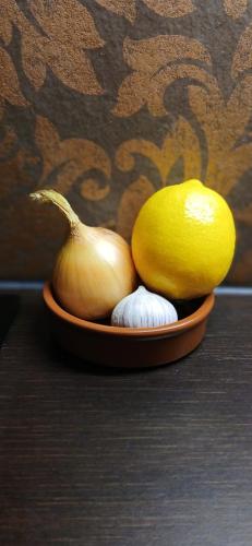 a bowl of onions and a lemon and garlic at Gouda city center apartment with private garden and 2 bicycles in Gouda