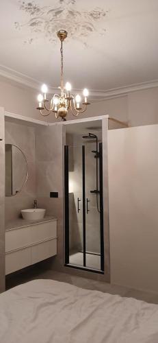 a bathroom with a sink and a chandelier at Gouda city center apartment with private garden and 2 bicycles in Gouda