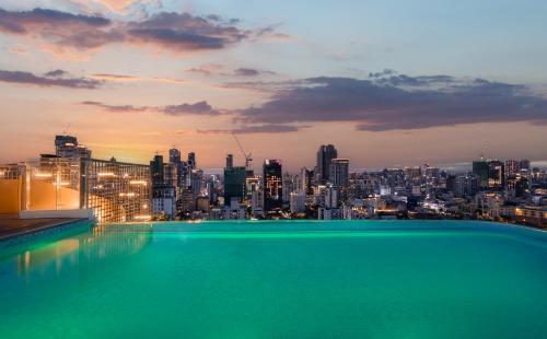 a rooftop swimming pool with a view of a city at Bassac Signature Hotel & Residence in Phnom Penh