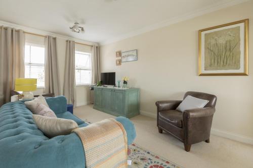 a living room with a blue couch and a chair at Castle Mill View in Oxford