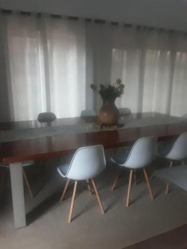 a table with chairs and a vase on top of it at Albertinia Homes in Albertinia