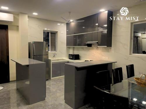 a kitchen with a refrigerator and a counter top at Quickpeak Villa by Staymist in Kelavli