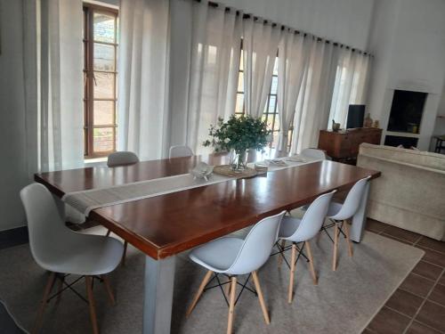 a dining room table with white chairs around it at Albertinia Homes in Albertinia