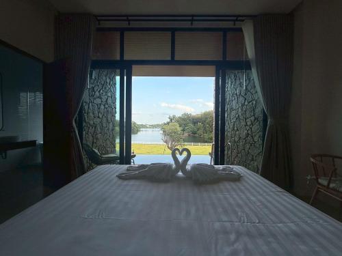a bedroom with a bed with a view of a window at รามโรมวัลเลย์รีสอร์ท Ramrom Valley Resort in Ban Loeng