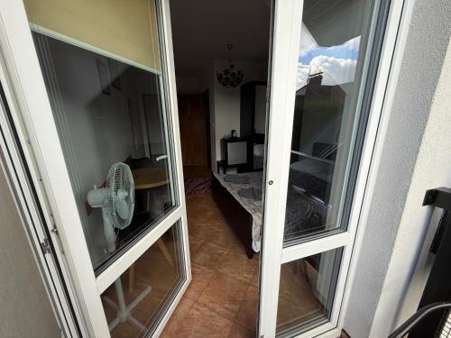a room with two glass doors and a fan at VITA Augustów in Augustów