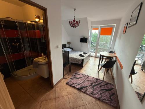 a bathroom with a toilet and a shower and a bedroom at VITA Augustów in Augustów