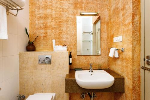 a bathroom with a sink and a mirror at Serenity Farm & Ayurvedic Retreat in Ernakulam
