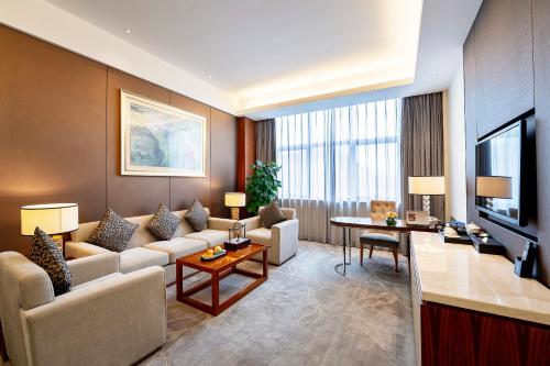 a living room with a couch and a table at Jinling Grand Hotel in Hefei