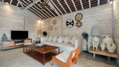 a living room with a couch and a table at Villa Taramille by Villa Finder in Kerobokan