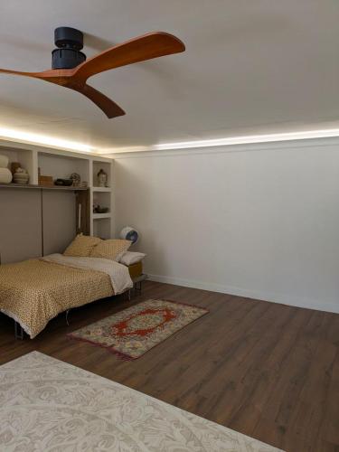 a bedroom with two beds and a ceiling fan at Le Daou Sormiou in Marseille