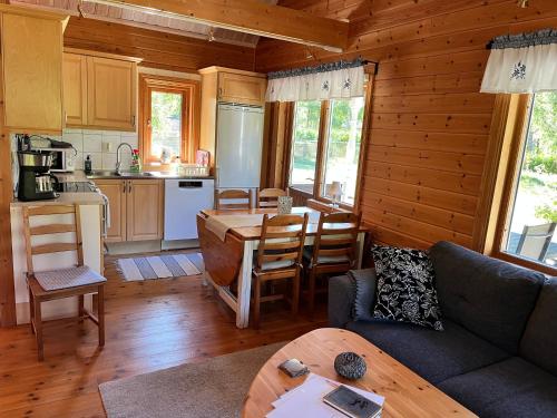 a living room with a couch and a kitchen at Tallbarren in Rälla