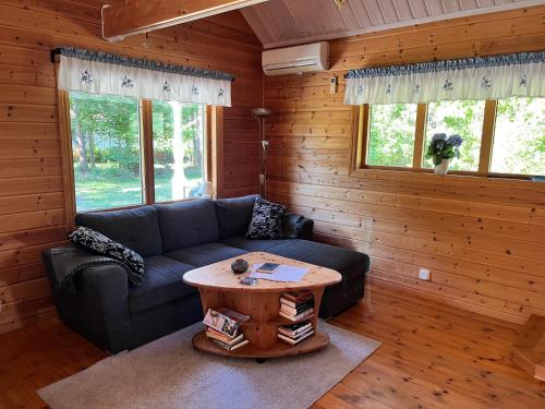 a living room with a couch and a table at Tallbarren in Rälla