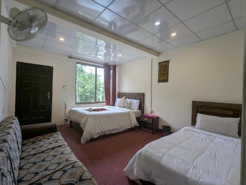 a hotel room with two beds and a window at Punjab Hotel and Resort in Sumaiyar