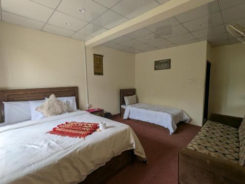 a bedroom with a large bed and a chair at Punjab Hotel and Resort in Sumaiyar