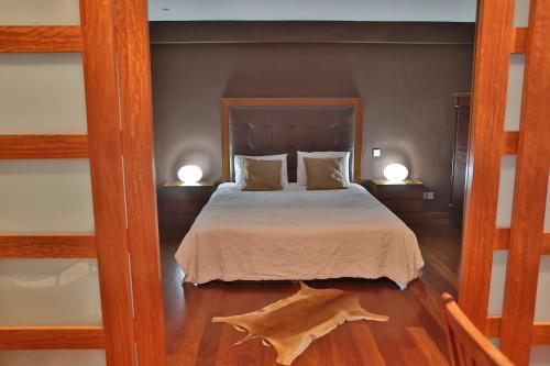 a bedroom with a bed with two lamps and a wooden floor at Sofouli Suites in Nicosia
