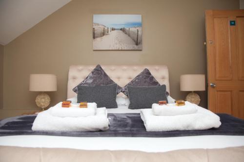 a bedroom with a large bed with two pillows at Washington House Hotel in Bournemouth