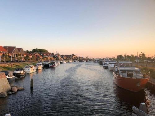 a group of boats are docked in a river at Holiday Home in Harderwijk near Veluwemeer in Harderwijk