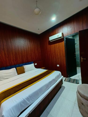a bedroom with a large bed with a red wall at The royal hotel in Bareilly