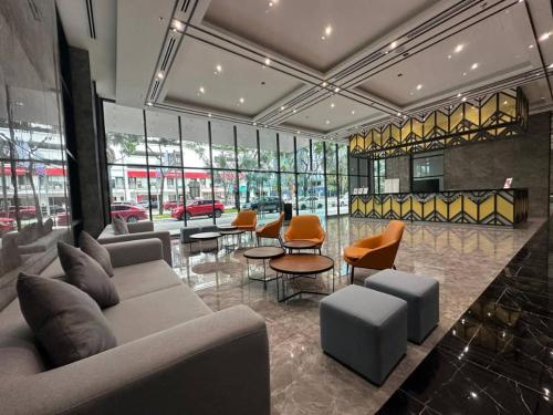 a lobby with couches and chairs and tables and windows at Alinea suites DSM near by shah alam in Shah Alam