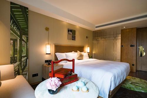 a hotel room with a bed and a table with flowers at LN Hotel Five in Guangzhou