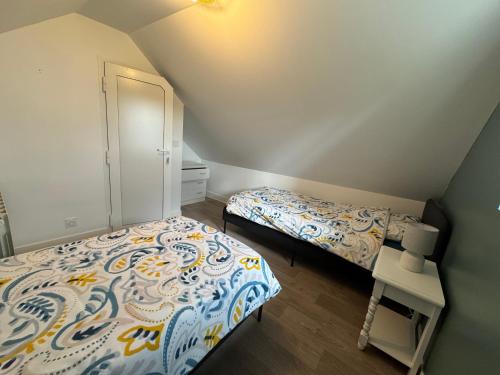 a bedroom with two beds and a closet at Charmante maison de campagne in La Hoguette