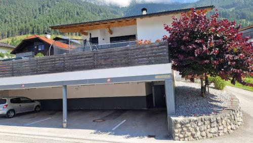 a building with a car parked in a parking lot at Ferienwohnung Bergzauber in Maurach