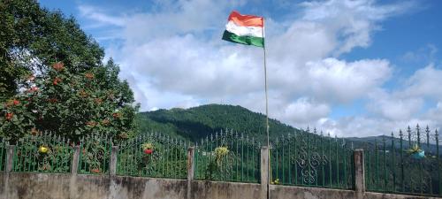 a flag flying over a fence next to a mountain at Tranquil Retreat Homestay in Ghum