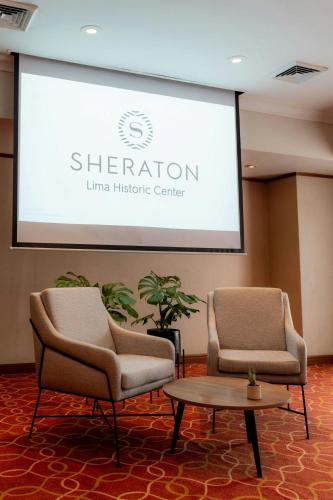 two chairs and a projector screen in a room at Sheraton Lima Historic Center in Lima