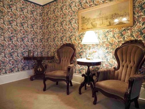 two chairs and a table in a room with wallpaper at Hotel Boulderado in Boulder