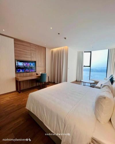 a bedroom with a large white bed and a desk at A La Carte in Ha Long