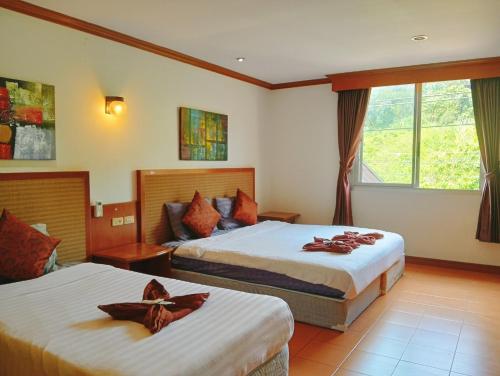a hotel room with two beds and a window at Haweli Restaurant & Guest House in Ao Nang Beach