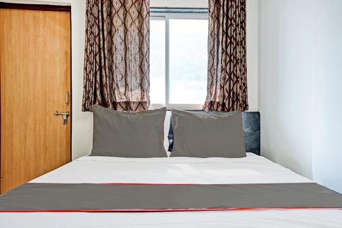 a bed in a room with a window at Hotel O Maurya in Pune