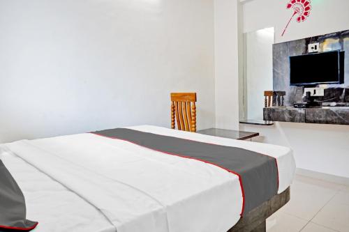 a bedroom with a bed and a tv in it at Hotel O Maurya in Pune