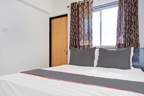 a bedroom with a large bed with a window at Hotel O Maurya in Pune