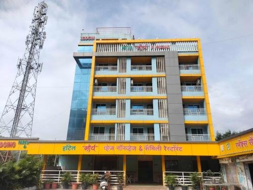 a tall yellow building with graffiti on it at Hotel O Maurya in Pune