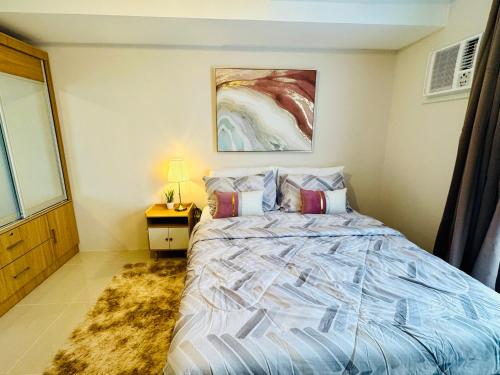 a bedroom with a bed and a painting on the wall at J Tower Residences in Mandaue City