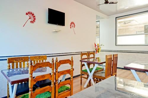 a dining room with a table and chairs and a television at Hotel O Maurya in Pune