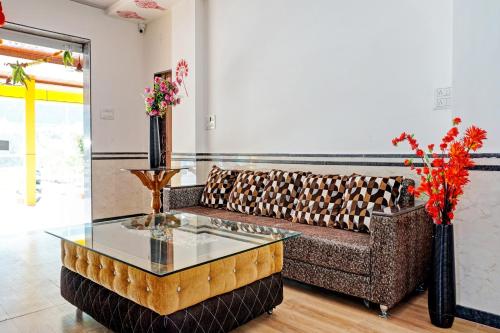 a living room with a couch and a glass table at Hotel O Maurya in Pune