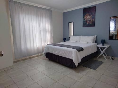 a bedroom with a large bed and a window at MV self-catering 3 Units in Bloemfontein