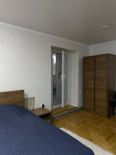 a bedroom with a bed and a sliding glass door at In hotel in Kamianets-Podilskyi