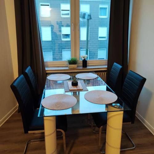 a dining room table with chairs and a window at Ferienwohnung 2-Zimmer im Herzen von Osnabrück in Osnabrück