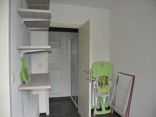 a bathroom with a green chair in a room at Apartment in Antwerp near Verbeke Museum in Puivelde