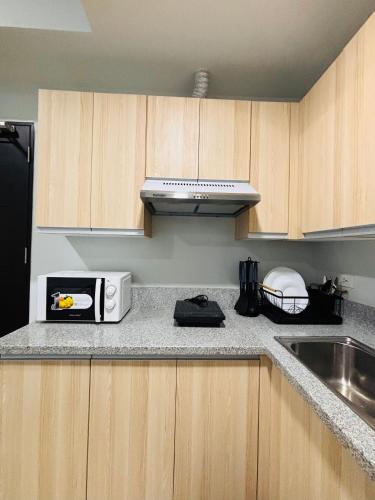a kitchen with a counter top with a microwave at Simple Stylish Retreat with Cozy Touches in Mandurriao