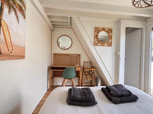 a bedroom with a bed and a desk and a chair at Olivia Plage, charmante maison lumineuse au calme bien équipée à 100 m plage d Asnelles, 500 m commerces, proche Arromanches et Bayeux, au coeur des plages du débarquement, jardin clos, deux belles terrasses, parking dans propriété in La Celle-sous-Gouzon