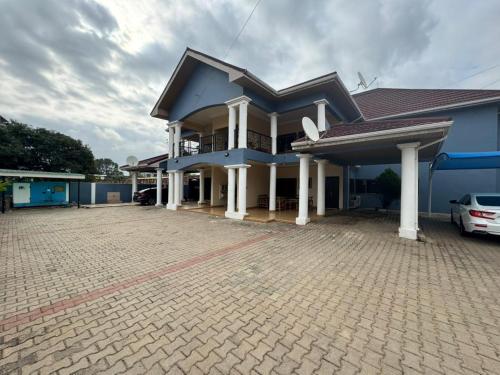 a blue house with a car parked in front of it at Christie's Apartment in Accra